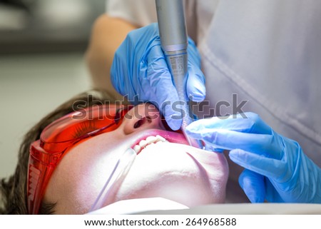 Patient in dentist office - cleaning and repairing teeth