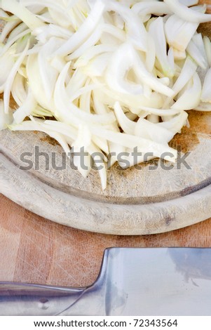 Cut onion on kitchen board with silver knife