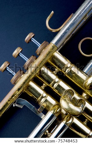 Brass music instrument - part of vintage golden trumpet on black background