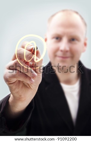 Man writing e-mail sign on virtual board - stock-photo-man-writing-e-mail-sign-on-virtual-board-91092200