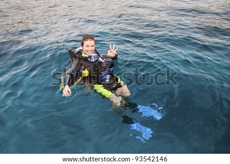 Portrait of a female scuba diver on the surface of the sea with diving equipment