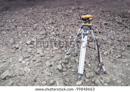 Land-surveying instrument mounted on tripod.