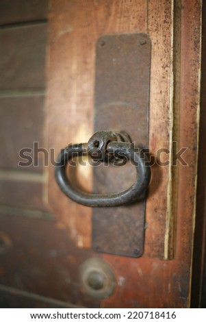Old rusty gate latch on the door. Fragment of old wooden door with rusty metal handle
