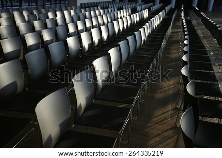 Endless rows of chairs in a modern conference hall. Rows of empty chairs prepared for an indoor event