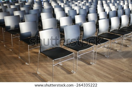 Rows of empty chairs prepared for an indoor event. Endless rows of chairs in a modern conference hall