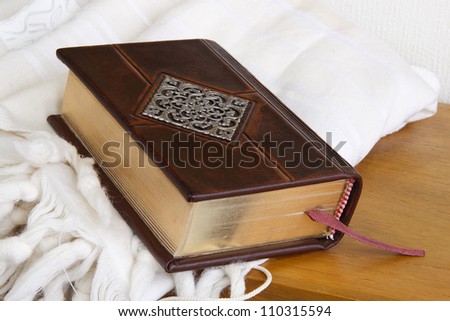 Book in leather cover with a bookmark put on white cloth. Brown Leather diary