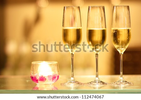 Three glasses of champagne with candle waiting to be served by guests in a restaurant