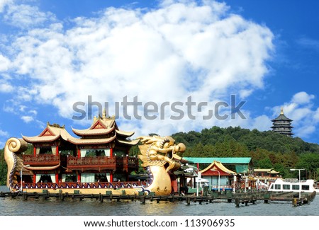 Oriental Dragon boat and Leifeng Pagoda on famous Xihu West Lake with blue sky, Hangzhou, China
