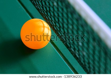 Table tennis ball on table with net