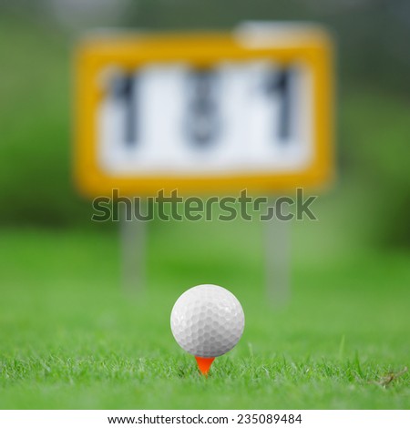 Golf ball on orange tee in golf course with 181 yardage markers