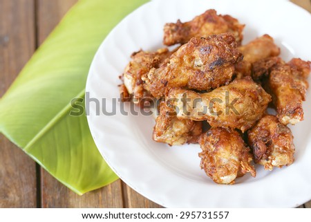Deep fried chicken wings on table wood and green leaf