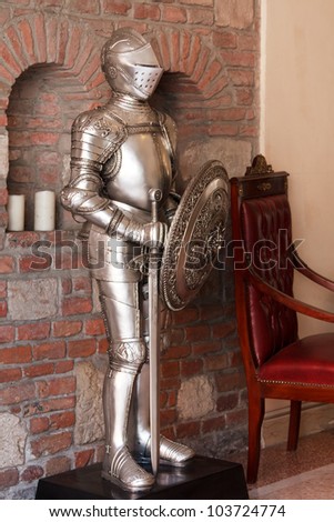 A knight\'s armour with shining metal and ornate shield and sword