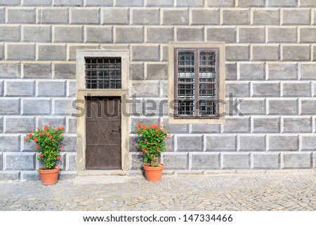 A wall with fake tiles with a door and flowers
