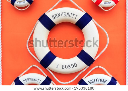 Floating tires on a wall of a boat indicating welcome aboard in english and italian