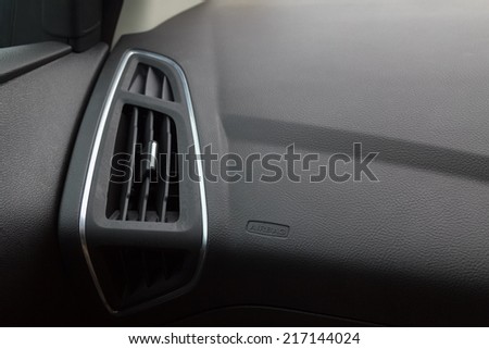 Close up of an air conditioner slot in a car with an airbag sign