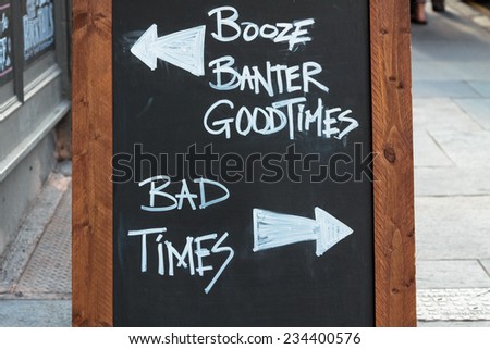 Chalk board in front of a pub with good times versus bad times
