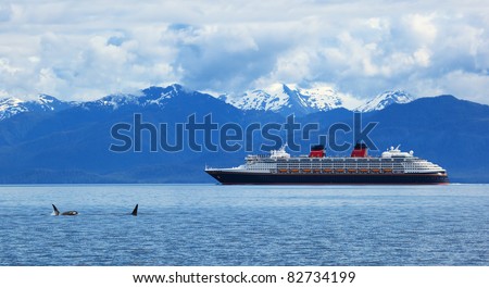 Two orca whales     and cruise  liner are shown on snow mountains   background, Alaska, the USA