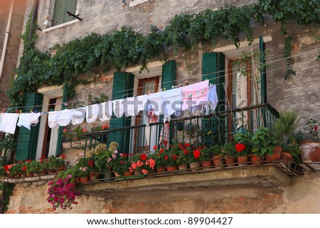 The clothes and bed-clothes is dried on a balcony. Venice cityscape, Italy