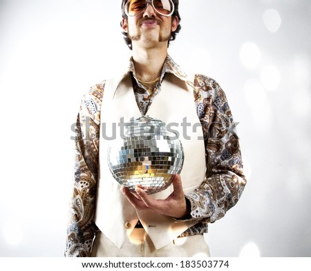 Instagram style portrait of a retro man in a 1970s leisure suit and sunglasses holding a disco ball - mirror ball
