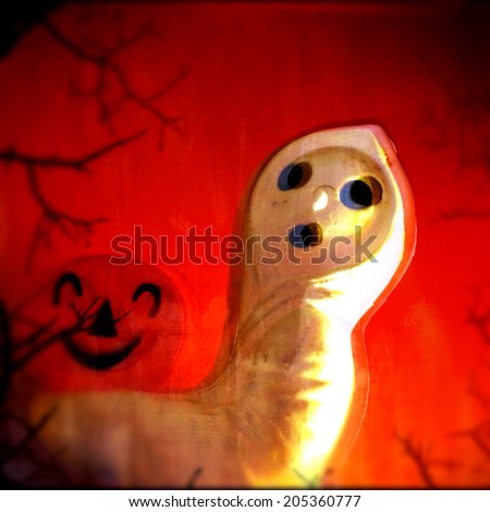 Instagram filtered image of a Halloween ghost carrying a jack o lantern