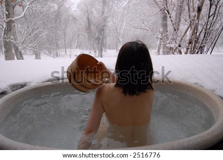 stock photo young Japanese woman in an open air hot onsen bath