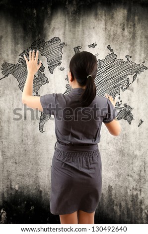 Business Lady touching world map drawing on the wall.