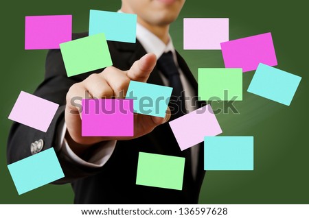 Businessman pushing sticky note on the whiteboard.