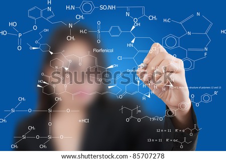Asian lady teacher writing science diagram.