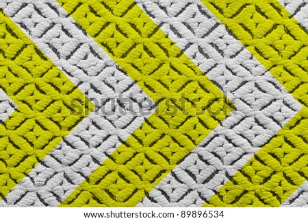 Yellow and black warning sign on fabric texture.