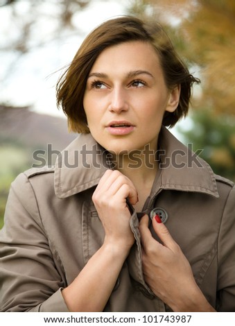 Portrait of a happy beautiful woman in autumn park, pale colors
