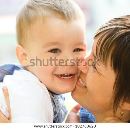 Portrait of a happy mother hugging her son outdoors