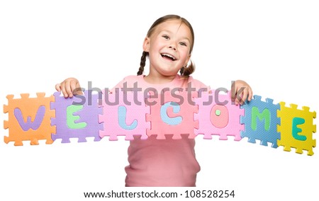 Cute little girl is holding Welcome slogan, isolated over white