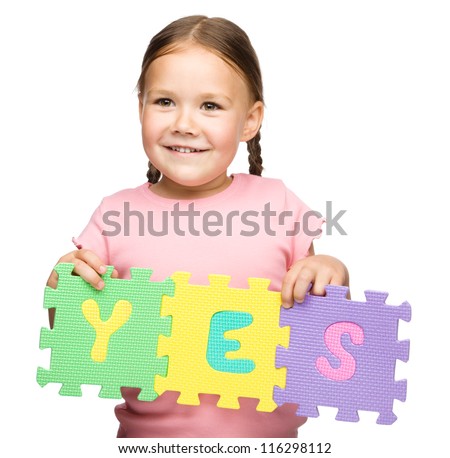 Cute little girl is holding Yes slogan, isolated over white