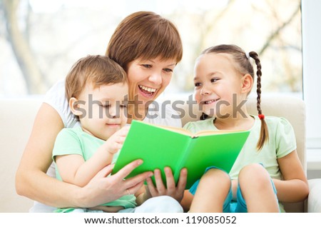 Mother is reading book for her two children, indoor shoot