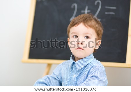 Little boy is sitting on math lesson in preschool