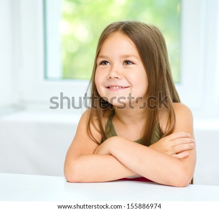 Little girl is crossing her arms while listening to somebody