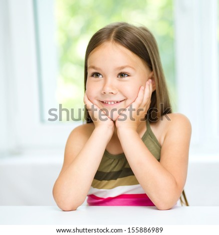 Little girl is holding her face while listening to somebody