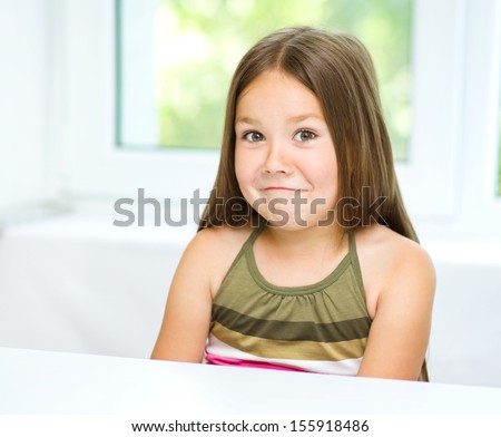 Little girl is showing grimace while listening to somebody