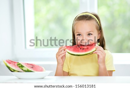Cute little girl is eating watermelon, isolated over white