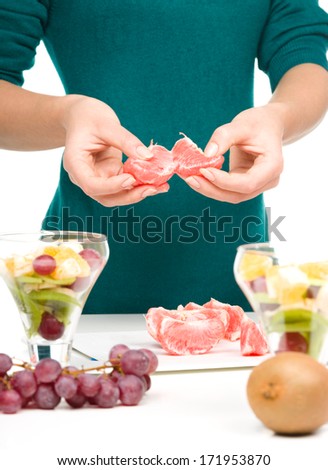 Cook is peeling grapefruit for fruit dessert, closeup shoot, isolated over white