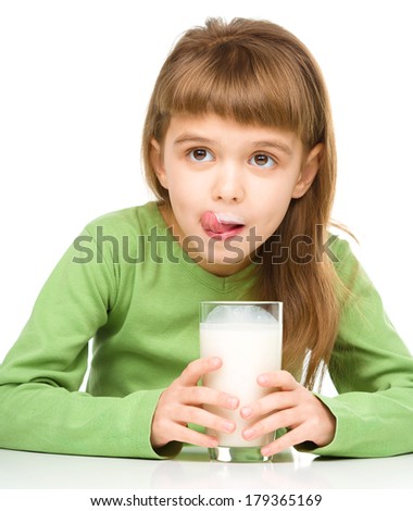 Cute little girl showing milk moustache and licking her lips, isolated over white