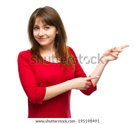 Portrait of a young woman pointing to the right using both hands, isolated over white