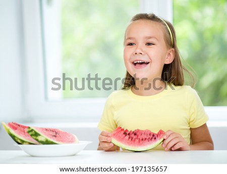 Cute little girl is eating watermelon, isolated over white