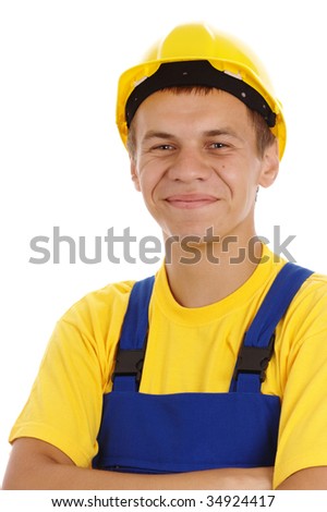 Happy worker fold his arms, dressed in blue-and-yellow uniform and hard hat, isolated over white