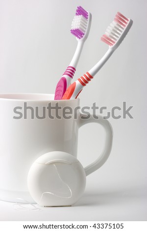 stock photo : Two toothbrushes in a cup and dental floss - common toiletries