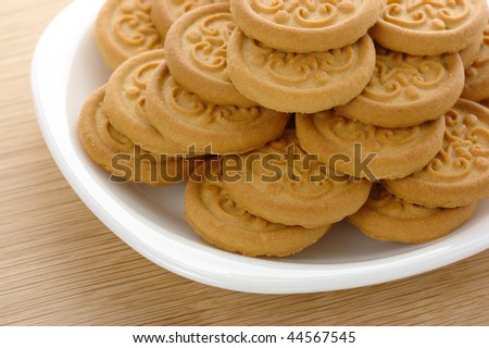 Fresh yellow round cookies on white plate
