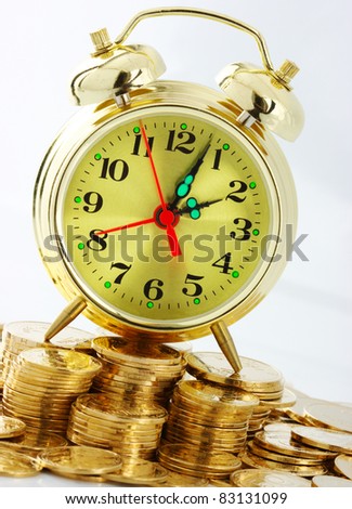 Old-fashioned clock dial on golden coins background, time is money concept