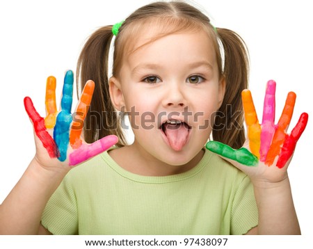 Portrait of a cute cheerful girl with painted hands who is showing her tongue, isolated over white