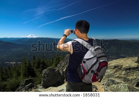 hiker taking picture of a remote mountain peak