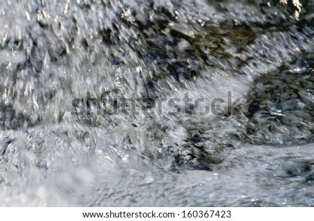 The texture of the raging stream of water flow in the river